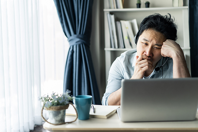 Asian young businessman working from home, man feeling tired, bored and sleepy sitting on table